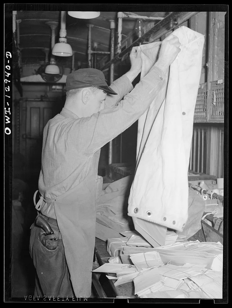 Emptying a sack of mail on board a mail car, 1938
