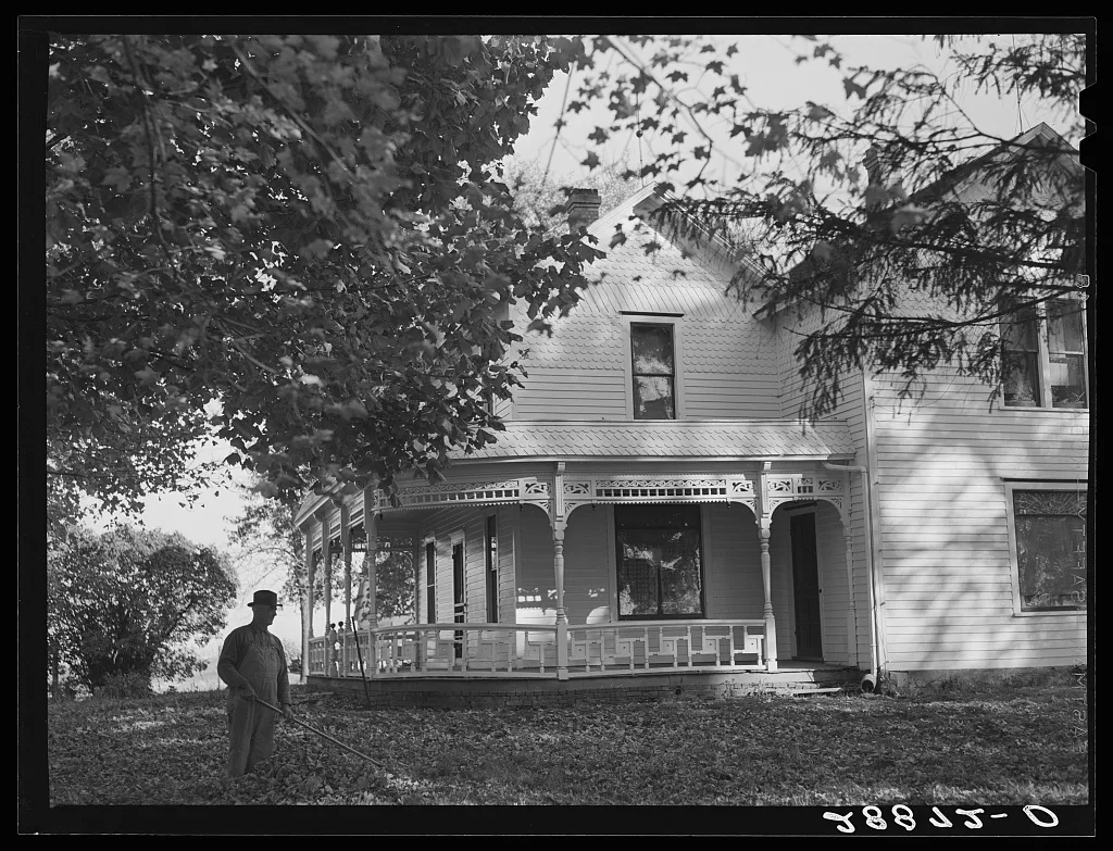 [Untitled photo, possibly related to: Farmer raking leaves on lawn of…, Iowa, 1939