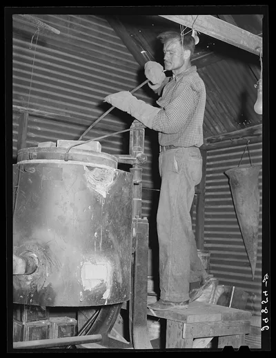 Stirring molten gold and silver in furnace. El Dorado Canyon, Nevada, 1940